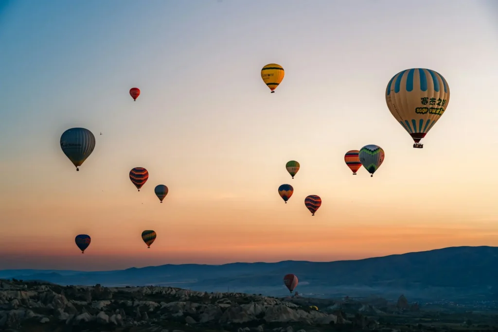 Colorful hot air balloons flying over the Winthrop Balloon Roundup in Winthrop WA with the North Cascades and Methow Valley in the background.